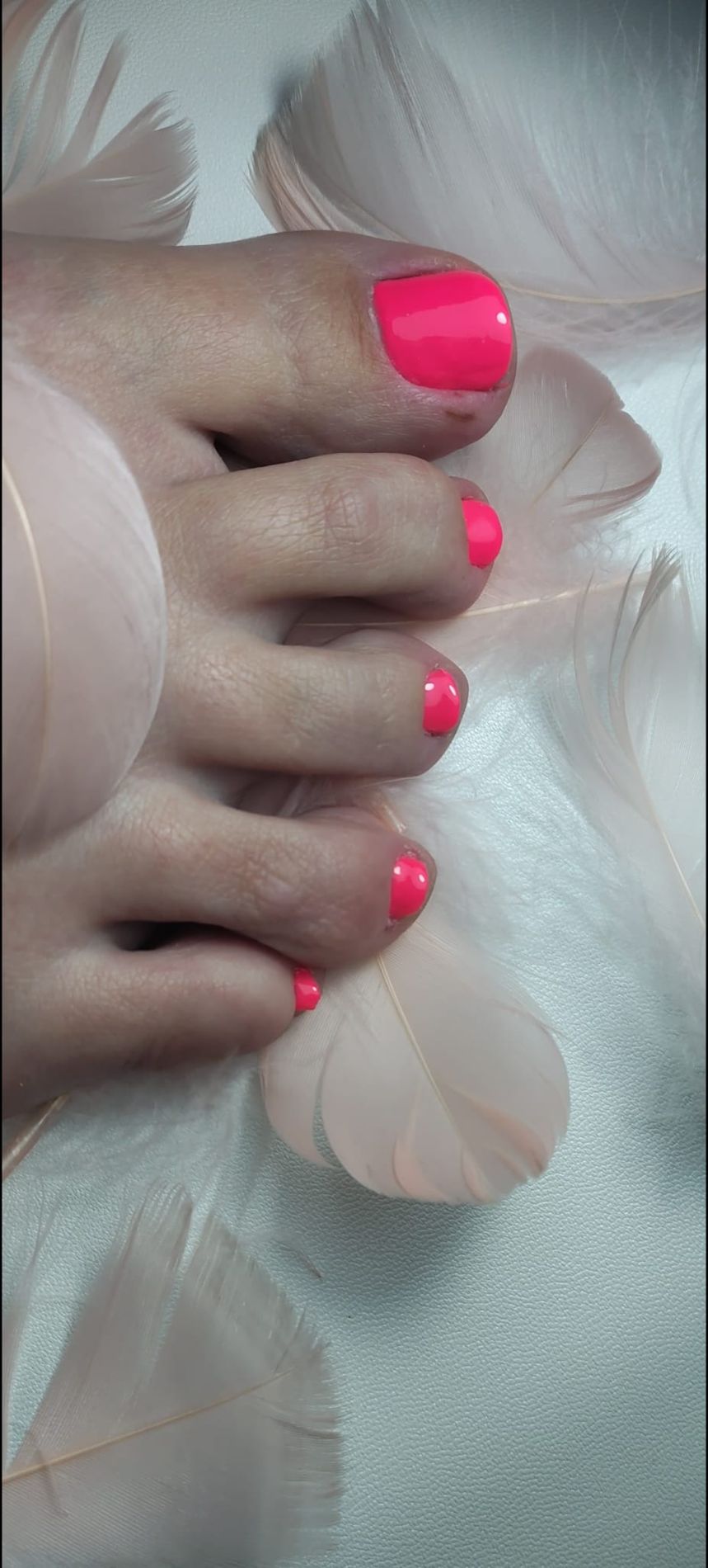 Felroze gellak op de teennagels tussen zachtroze veren
